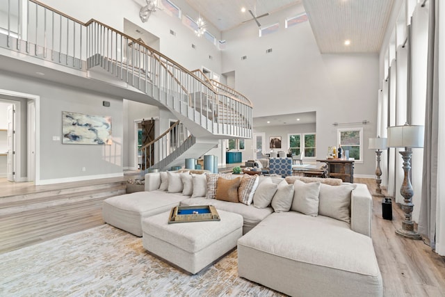 living room with light wood-type flooring and a towering ceiling