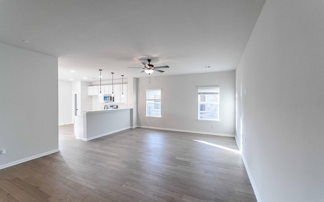 unfurnished living room featuring hardwood / wood-style flooring and ceiling fan