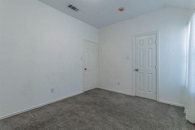 carpeted empty room with lofted ceiling