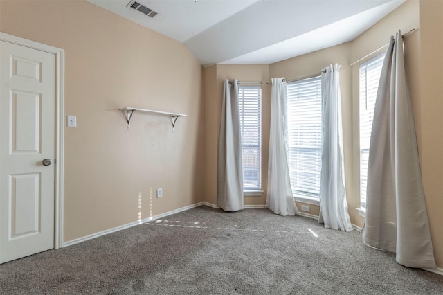 empty room with carpet flooring, plenty of natural light, and vaulted ceiling