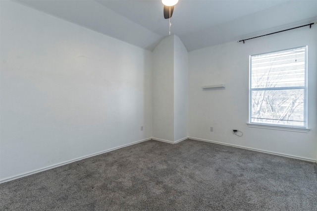 empty room featuring dark colored carpet, ceiling fan, and lofted ceiling