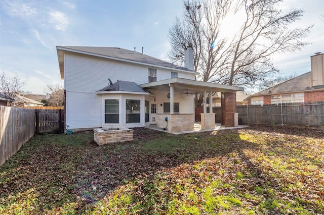 back of property with ceiling fan and a patio area