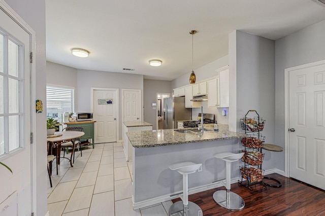 unfurnished living room with a tile fireplace, wood-type flooring, and ceiling fan