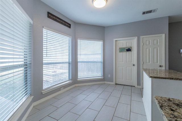 unfurnished dining area featuring light tile patterned flooring