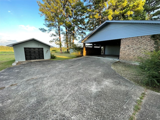 detached garage featuring a carport and driveway