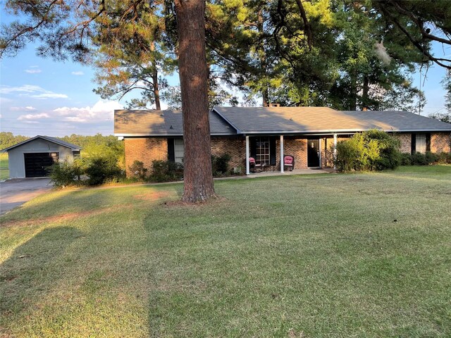 ranch-style home with a garage, an outdoor structure, and a front lawn