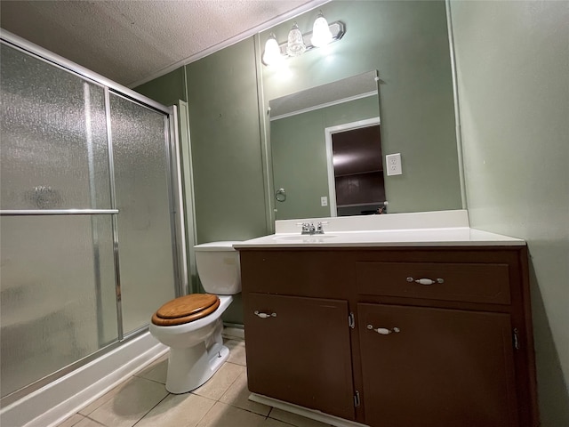 bathroom featuring toilet, a stall shower, vanity, a textured ceiling, and tile patterned flooring