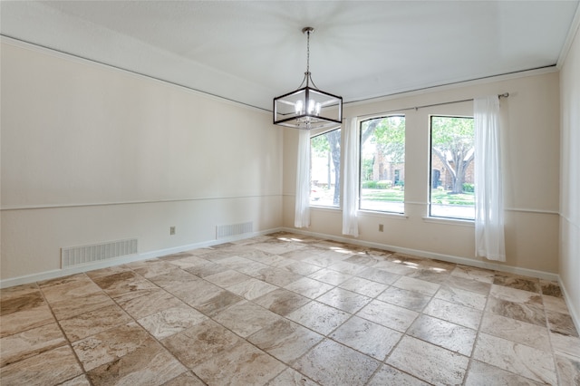 spare room with a notable chandelier and crown molding