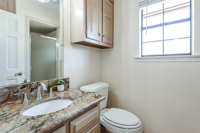 bathroom featuring vanity, an enclosed shower, and toilet