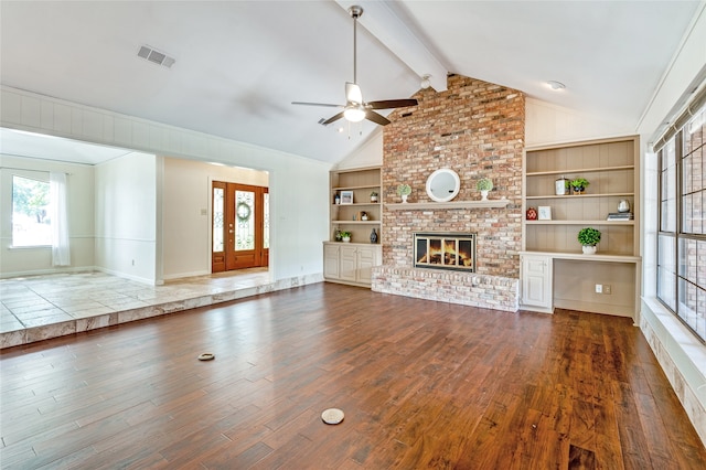 unfurnished living room featuring vaulted ceiling with beams, dark hardwood / wood-style flooring, built in shelves, and a brick fireplace