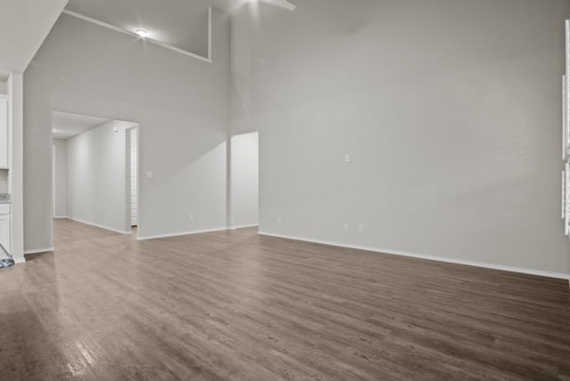 unfurnished living room with hardwood / wood-style floors and a high ceiling