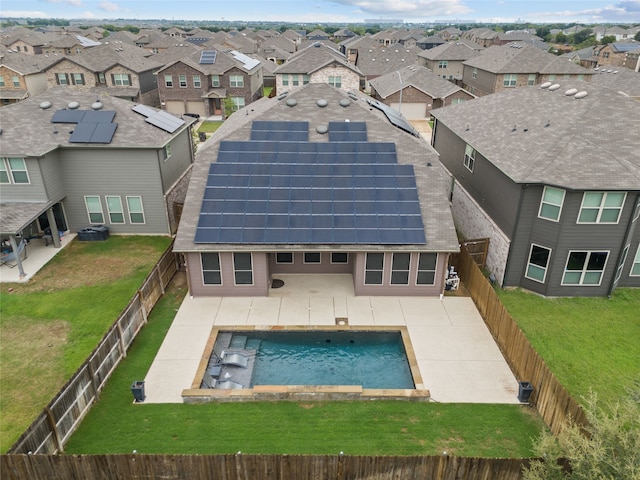 rear view of property with a yard, a patio area, and solar panels