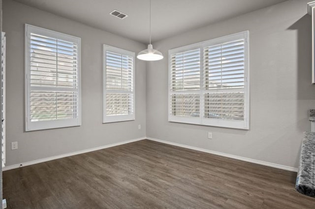 unfurnished dining area featuring plenty of natural light and dark hardwood / wood-style floors