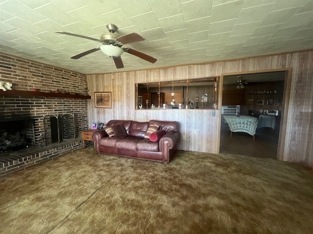 living room with brick wall, ceiling fan, wood walls, and a fireplace