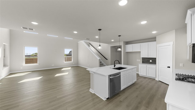 kitchen with a kitchen island with sink, appliances with stainless steel finishes, sink, and white cabinetry