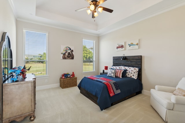 carpeted bedroom featuring multiple windows, a raised ceiling, baseboards, and ornamental molding