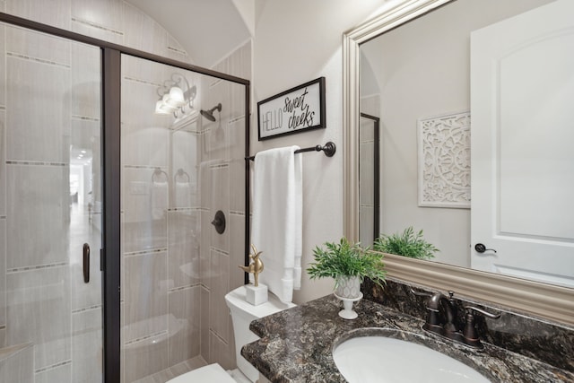 bathroom with a shower stall, vanity, and toilet