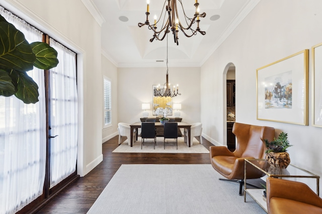 dining room with crown molding, a notable chandelier, arched walkways, and dark wood-style flooring