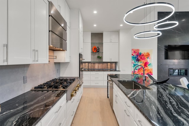 kitchen with dark stone countertops, sink, stainless steel appliances, and white cabinets