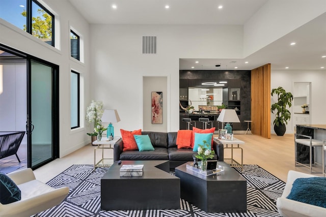 living room with a high ceiling and a healthy amount of sunlight