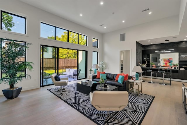 living room featuring a high ceiling and light hardwood / wood-style flooring