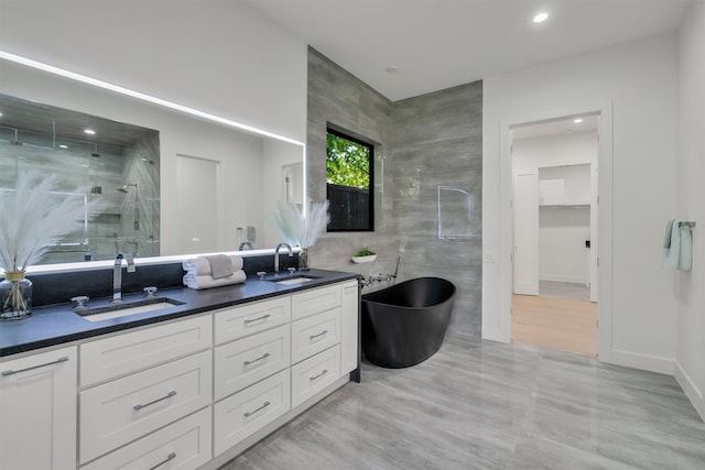 bathroom with vanity, independent shower and bath, and tile walls