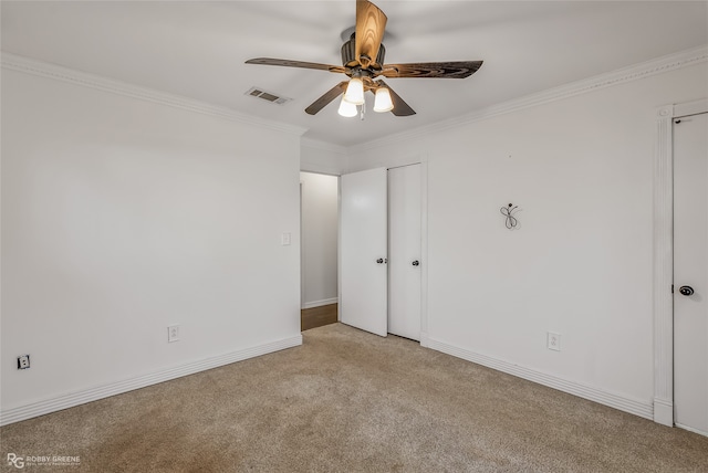 interior space featuring crown molding, light colored carpet, and ceiling fan