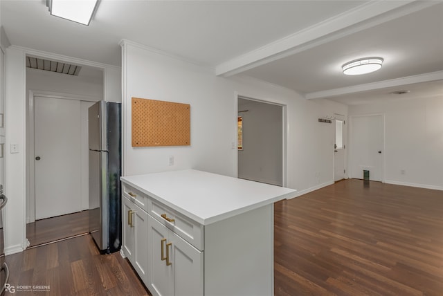 kitchen with dark hardwood / wood-style floors, stainless steel fridge, beamed ceiling, kitchen peninsula, and white cabinets