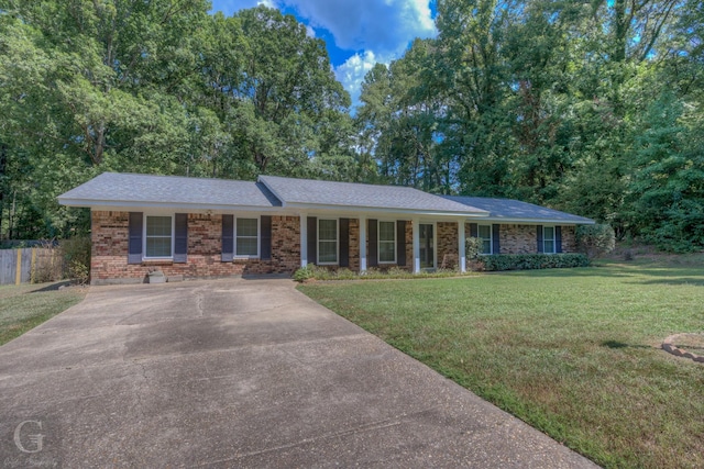 ranch-style house with brick siding, driveway, a front lawn, and fence