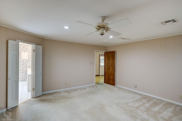 unfurnished room featuring ceiling fan, visible vents, light colored carpet, and ornamental molding