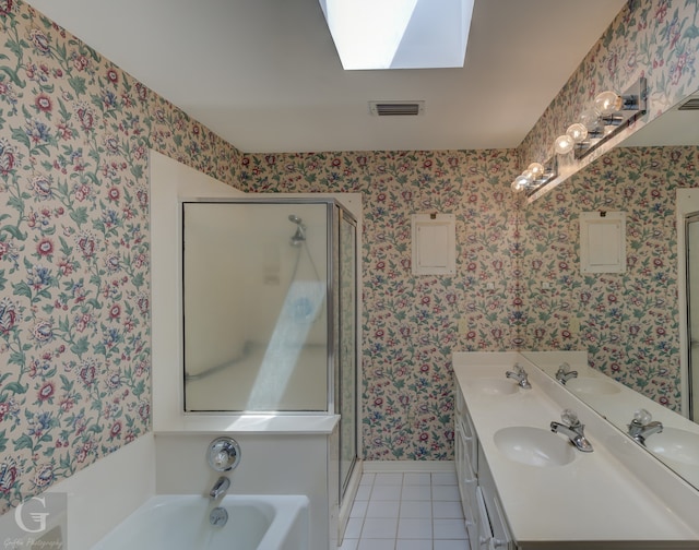 bathroom with vanity, a skylight, separate shower and tub, and tile patterned floors