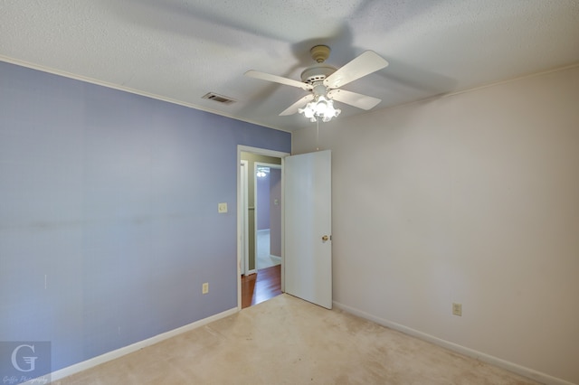 carpeted spare room with ceiling fan and a textured ceiling