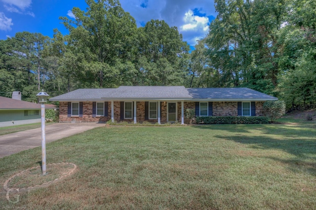 ranch-style home featuring concrete driveway, brick siding, and a front lawn