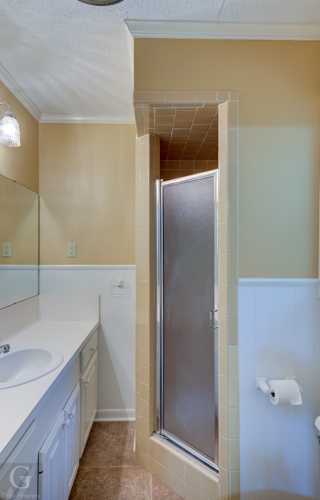 bathroom with a textured ceiling, vanity, an enclosed shower, tile patterned flooring, and crown molding