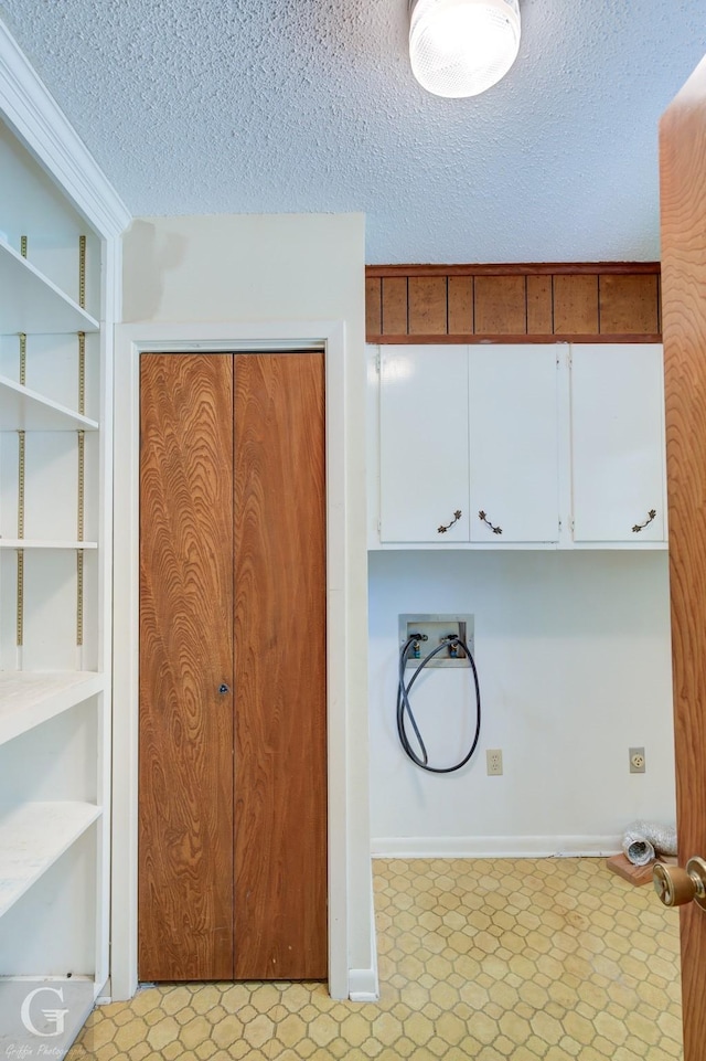 clothes washing area featuring hookup for a washing machine, built in features, a textured ceiling, and light floors