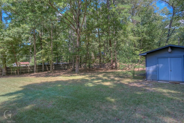 view of yard with a storage unit, fence, and an outdoor structure