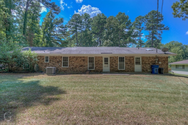 ranch-style home featuring central AC unit, a front lawn, and brick siding