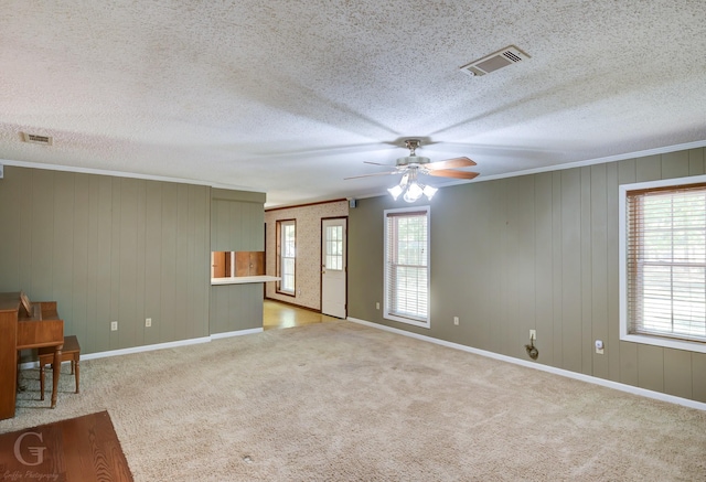 spare room featuring carpet floors, ceiling fan, visible vents, and ornamental molding