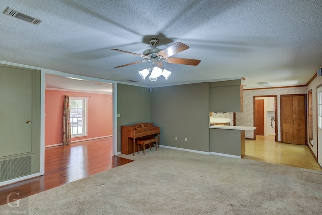 unfurnished room with a textured ceiling, ceiling fan, ornamental molding, and light hardwood / wood-style floors