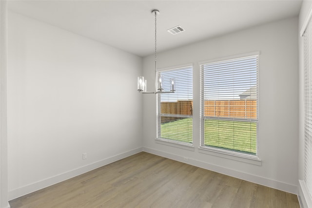 981 Stanford Ln, Prosper, TX 75078 - unfurnished dining area with light wood finished floors, a notable chandelier, baseboards, and visible vents
