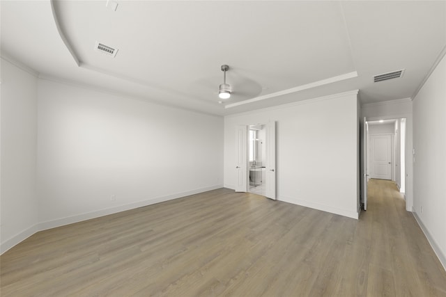 981 Stanford Ln, Prosper, TX 75078 - unfurnished bedroom with ornamental molding, light wood finished floors, a tray ceiling, and visible vents