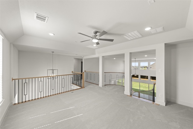 carpeted empty room with ceiling fan with notable chandelier