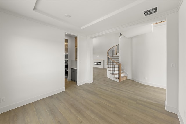 spare room with crown molding and hardwood / wood-style flooring