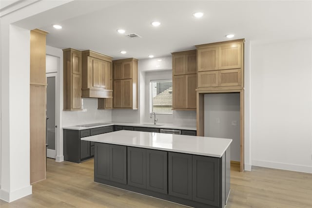 kitchen with stainless steel dishwasher, light hardwood / wood-style flooring, sink, black electric stovetop, and a center island