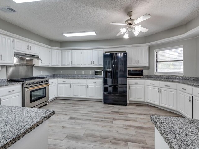 kitchen with white cabinets, ceiling fan, stainless steel appliances, and extractor fan