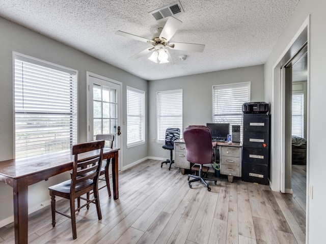 home office featuring a textured ceiling, light hardwood / wood-style flooring, and ceiling fan