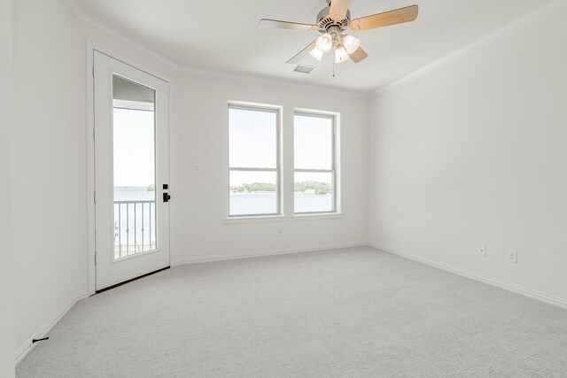 carpeted spare room featuring ceiling fan, plenty of natural light, and crown molding