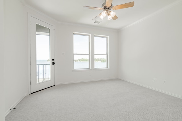 spare room featuring light carpet, baseboards, a ceiling fan, and crown molding