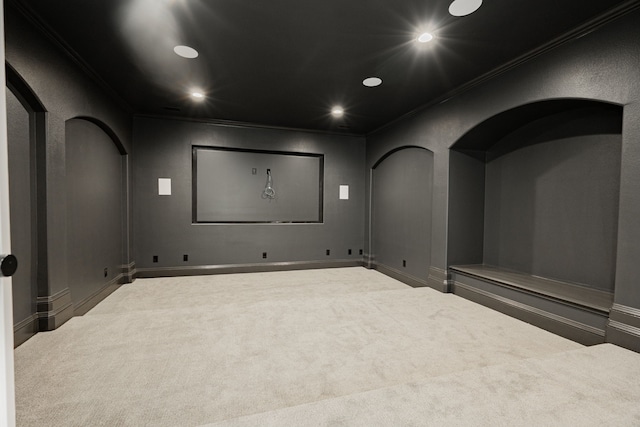 carpeted home theater with recessed lighting, arched walkways, and ornamental molding