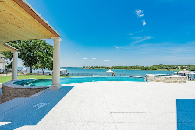 view of swimming pool with a patio area, a pool with connected hot tub, and fence